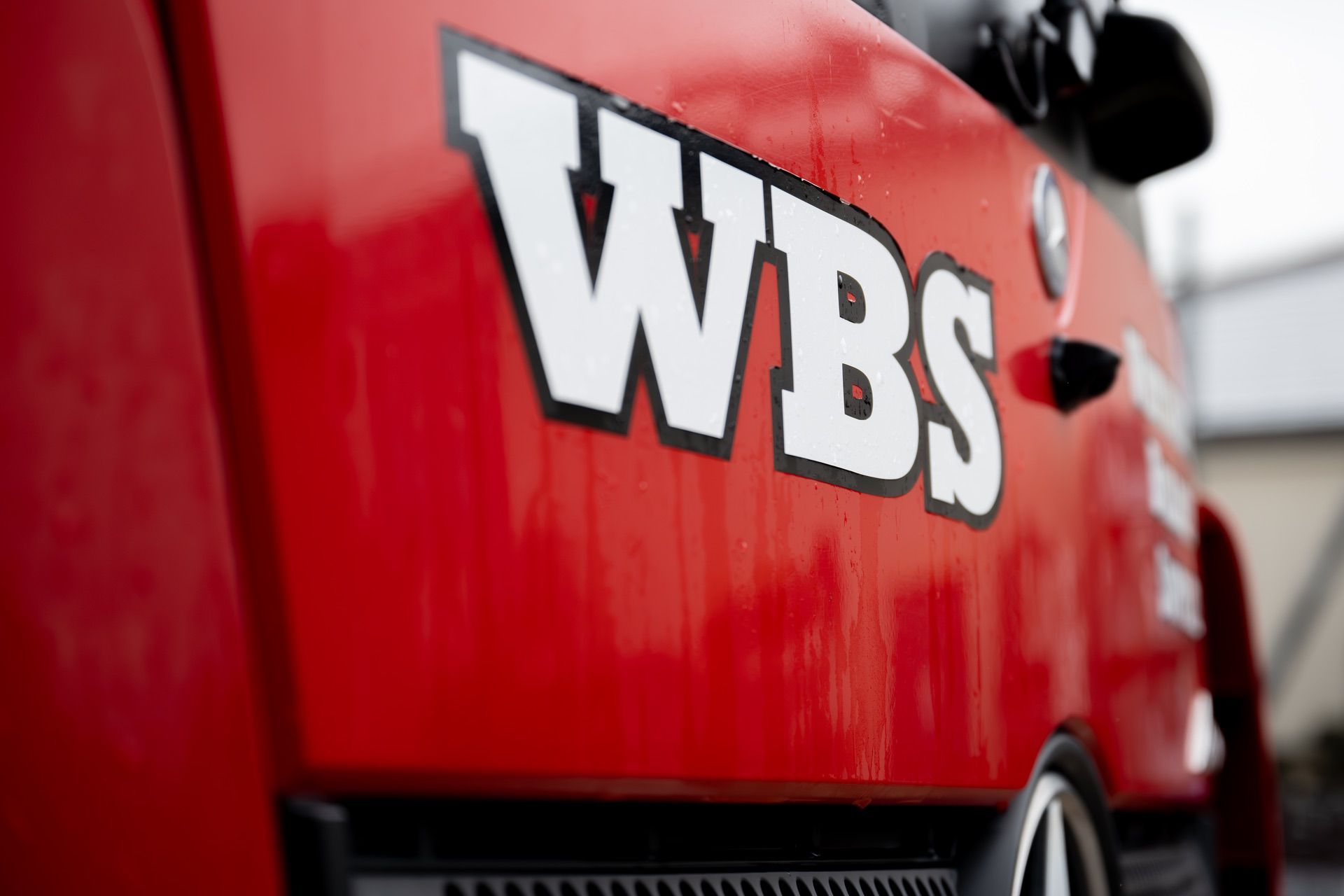 A close up of a red truck with the word wbs on it.