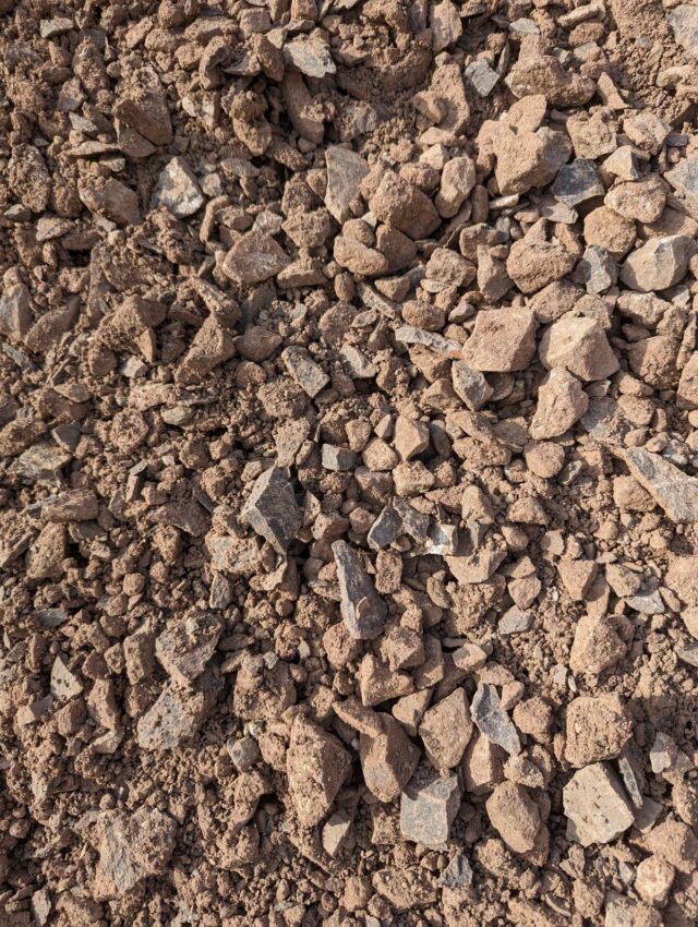 A close-up view of loose, uneven dirt and small rocks.